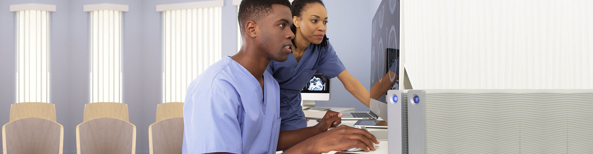 Two African American medical specialists working together on computer